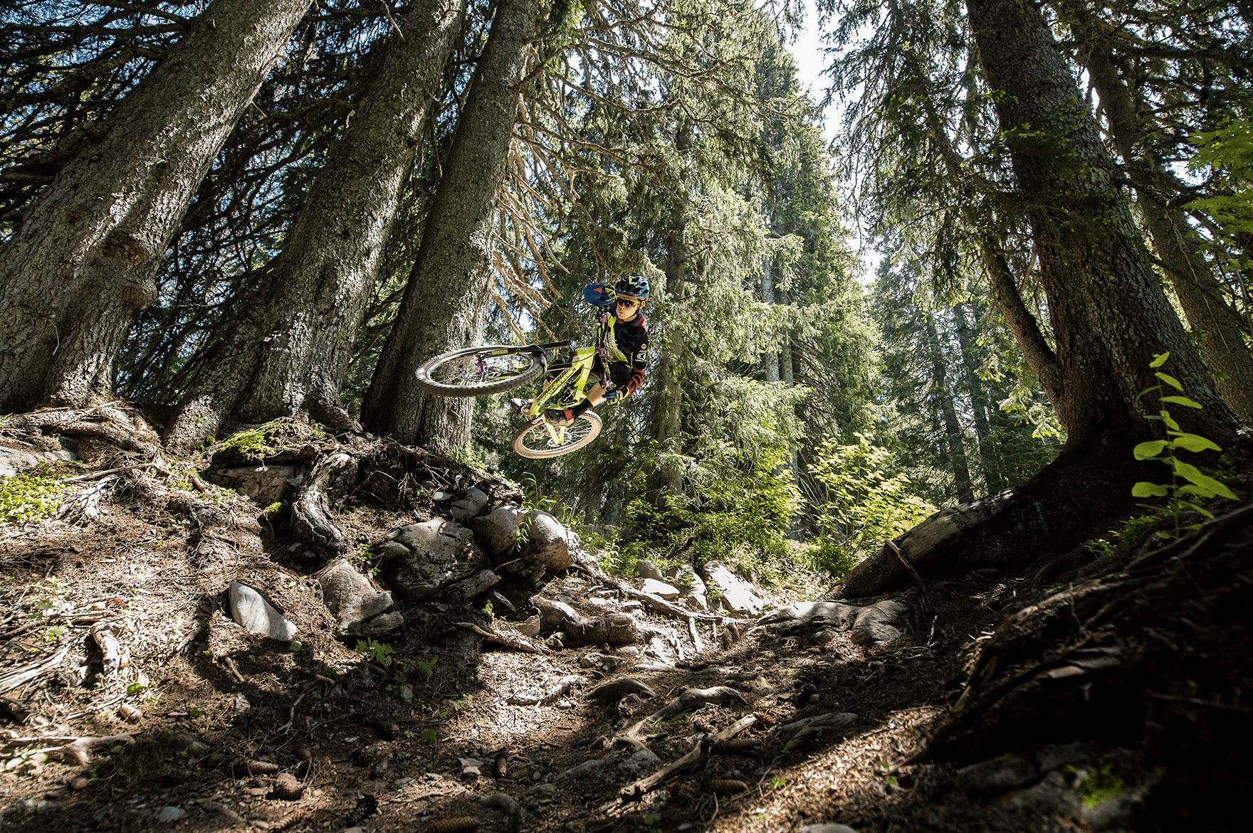 Location vélo Les Gets - Cycliste VTT descendant une piste ensoleillée aux Gets